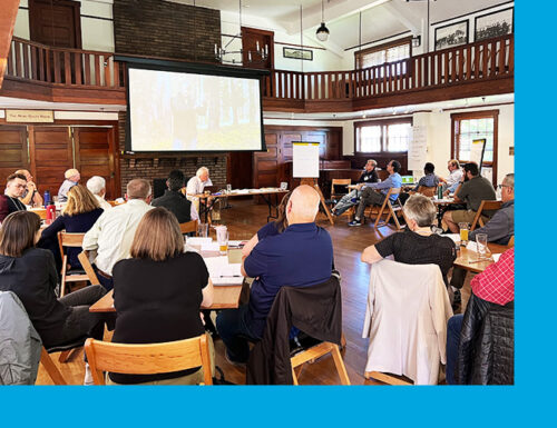 Diverse group of people sitting in a lodge looking at a speaker presentation