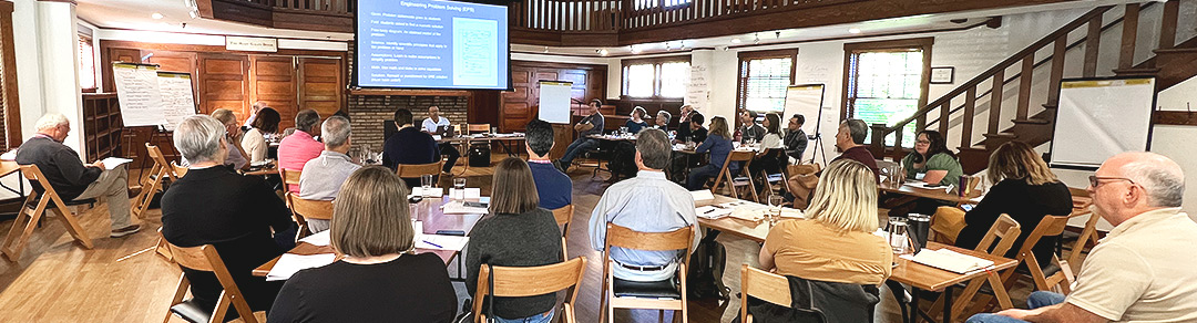 Group of change makers gather in a room with the speaker presenting for a powerpoint